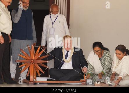 Le Premier ministre Boris Johnson montre comment faire fonctionner une roue en coton dans la maison de Mahatma Gandhi à l'Ashram Sabarmati à Ahmedabad lors d'une visite culturelle dans le cadre de sa visite de deux jours en Inde. Date de la photo : jeudi 21 avril 2022. Banque D'Images