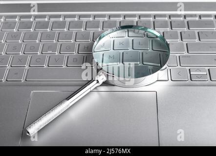 Loupe sur le clavier de l'ordinateur portable. Concept de recherche d'informations. Étude des bases de données numériques. Vérification effectuée à l'aide d'un ordinateur. Photo de haute qualité Banque D'Images