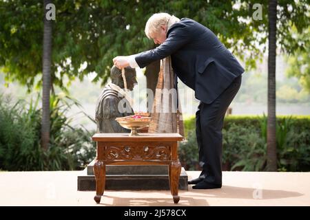 Le Premier ministre Boris Johnson place une guirlande autour du cou d'une statue du Mahatma Gandhi à son ashram Sabarmati à Ahmedabad dans le cadre de sa visite de deux jours en Inde. Date de la photo : jeudi 21 avril 2022. Banque D'Images