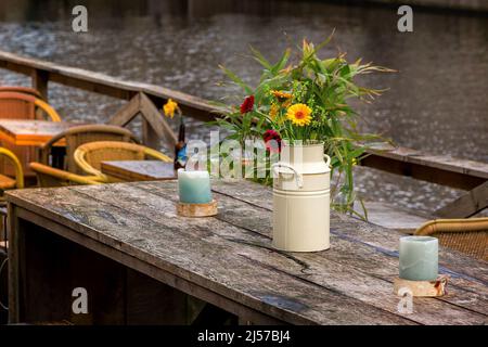 Confortable café de rue table en bois avec fleurs dans vase. Décor de restaurant extérieur avec bougies aux pays-Bas Banque D'Images