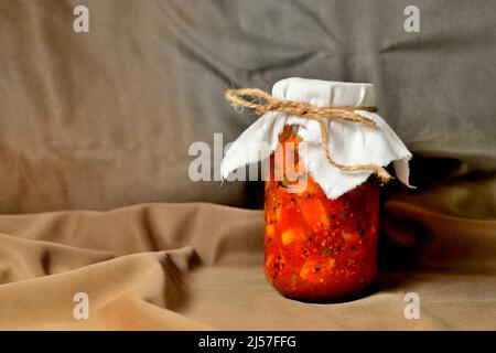 Cornichon de mangue cru fait maison dans une bouteille de verre sur fond marron Banque D'Images