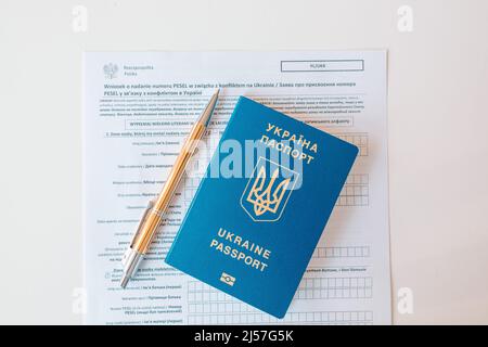 Document PESEL, passeport ukrainien et stylo sur fond de table blanc. Banque D'Images