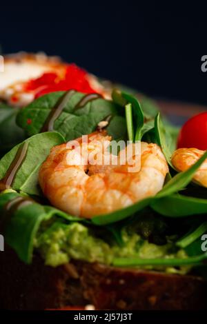 Pain de sarrasin toasts avec un œuf poché, un avocat en tranches, des crevettes, des tomates et de la laitue. Menu diététique. Pose à plat Banque D'Images