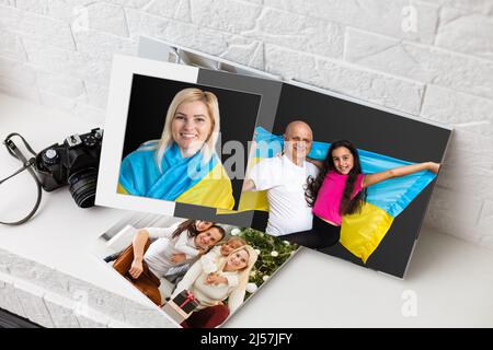 Archives photos de famille enregistrées dans un livre photo aux couleurs vives ; souvenirs d'été éclatants placés dans le livre photo. Famille avec drapeau de l'ukraine Banque D'Images