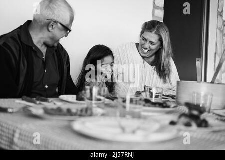 Les grands-parents heureux manger avec la petite-fille à la maison patio - Focus sur grand-mère visage - montage noir et blanc Banque D'Images