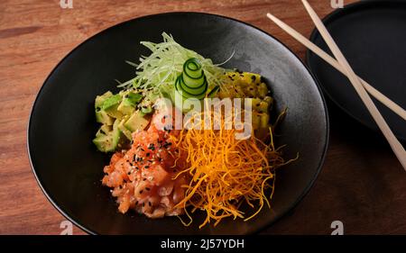 Poke Bowl, salade hawaïenne traditionnelle de saumon cru, avec baguettes et espace de copie. Mise au point sélective. Banque D'Images