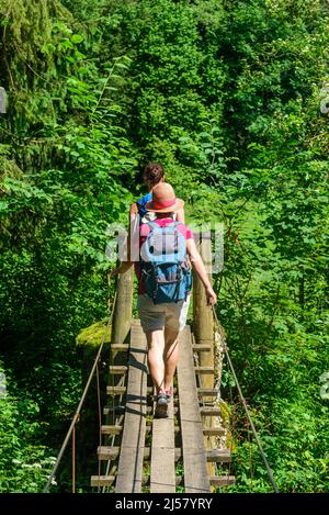 Un groupe de randonneurs traversant une petite passerelle au-dessus de la rivière Wertach près du village Wald dans le Banque D'Images