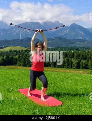 Femme faisant des exercices pilates avec barre vibrante Banque D'Images