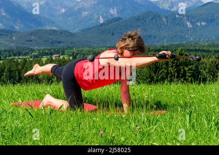 Femme faisant des exercices pilates avec barre vibrante Banque D'Images
