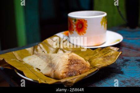 Tamale farcie servie sur une table en bois, tamale farcie sur une feuille de banane servie sur une table en bois, cuisine typique du nicaragua Banque D'Images