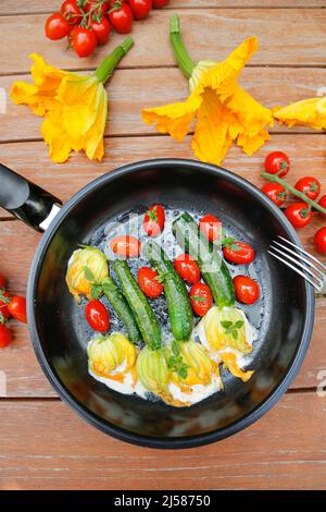 Cuisine du sud de l'Allemagne, fleurs de courgettes farcies sautées dans une poêle, fromage à la crème, tomates cocktail, tomates cerises, végétarienne, une cuisine saine Banque D'Images