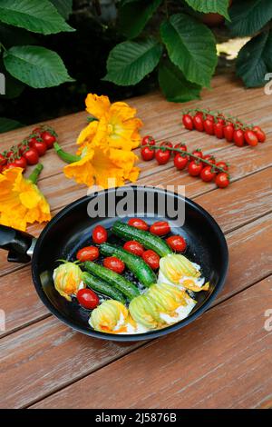 Cuisine du sud de l'Allemagne, fleurs de courgettes farcies sautées dans une poêle, fromage à la crème, tomates cocktail, tomates cerises, végétarienne, une cuisine saine Banque D'Images