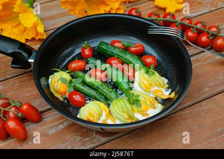 Cuisine du sud de l'Allemagne, fleurs de courgettes farcies sautées dans une poêle, fromage à la crème, tomates cocktail, tomates cerises, végétarienne, une cuisine saine Banque D'Images