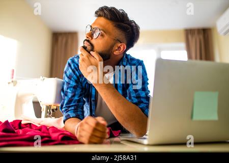 indian tailleur formation de l'homme et travail indépendant avec machine à coudre dans le nouvel appartement Banque D'Images