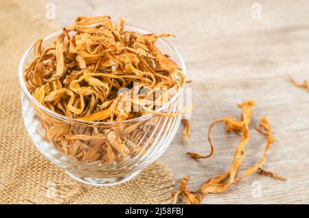 Le cordyceps militaris séché fleur de champignon sur fond de bois. Banque D'Images