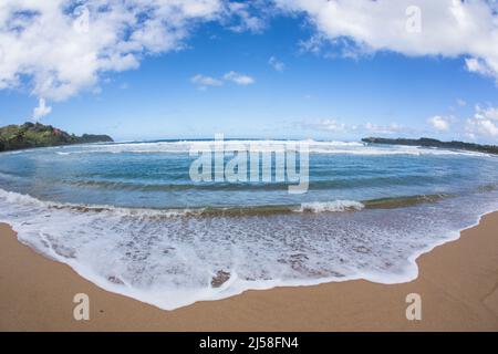 Vagues et surf sur Hanalei Beach sur l'île de Kauai, Hawaï, États-Unis. Photographié avec un objectif fisheye qui crée une image déformée. Banque D'Images