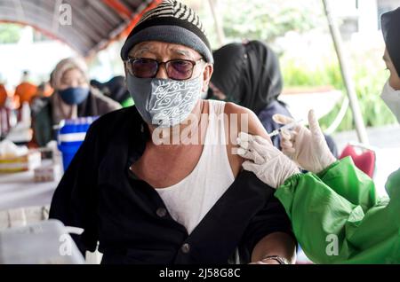 Bandung, Indonésie. 21st avril 2022. Un travailleur de la santé inocule un homme âgé avec une dose de rappel du vaccin COVID-19 à Bandung, West Java, Indonésie, le 21 avril 2022. Crédit: Septianjar/Xinhua/Alamy Live News Banque D'Images