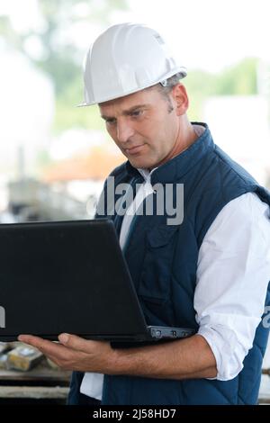 homme dans un casque travaillant à l'extérieur de l'ordinateur portable Banque D'Images