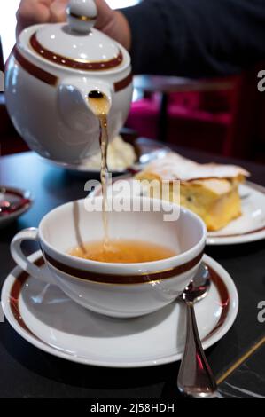 Temps du thé en Angleterre, verser du thé noir earl Grey avec bergamote dans une tasse, thé dînatoire servi café à Londres, gros plan Banque D'Images