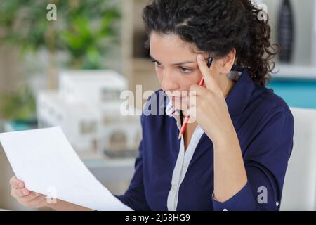 femme secrétaire profondément dans la concentration de la lecture d'une lettre Banque D'Images