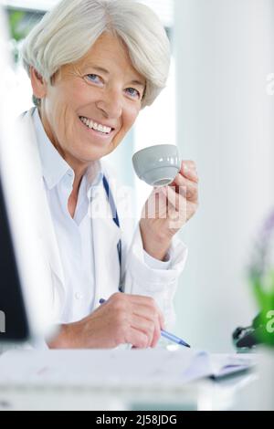 portrait d'une femme âgée élégante utilisant un ordinateur portable et buvant du café Banque D'Images