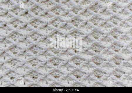 Gros plan sur une couverture en coton blanc avec un motif original en point de crochet en relief, créativité faite à la main Banque D'Images