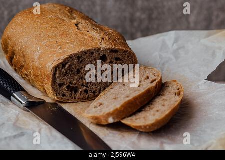 Pain au levain traditionnel, tranché sur une planche en bois, vue rapprochée. Banque D'Images