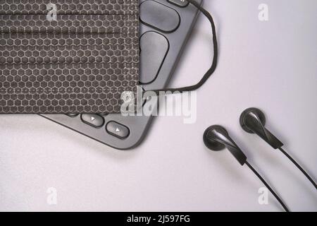 Concept de podcast. Enregistreur à microphone noir, clavier de l'ordinateur portable de contenu avec écouteurs noirs. Gros plan. Périphérique audio. Enregistrement de la production. Équipement de connaissances scolaires. Accueil enseignement en ligne. Gris Banque D'Images