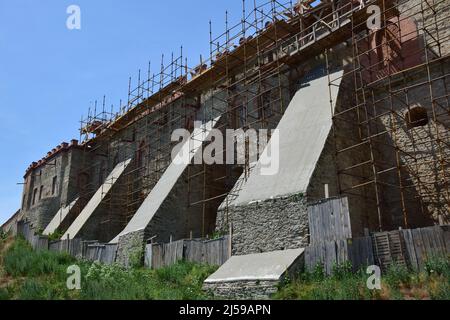 Un des murs d'une forteresse médiévale en pierre dans l'échafaudage de réparation de construction Banque D'Images