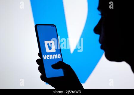 Dans cette illustration, une femme silhouetée tient un smartphone avec le logo Venmo affiché à l'écran. Banque D'Images