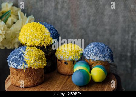 Délicieux gâteaux de Pâques sur une table en bois avec des fleurs en arrière-plan. Place pour le texte. Mise au point sélective Banque D'Images