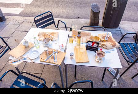 Table abandonnée avec chaises avec restes, plats vides, huile d'olive dans la rue dans le centre de Madrid, Espagne Banque D'Images