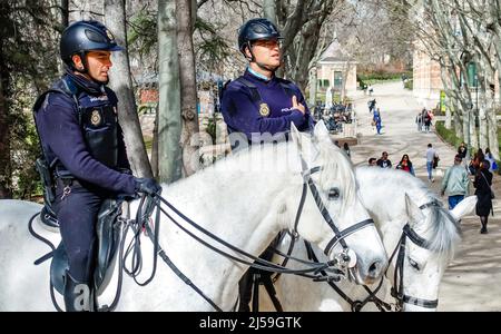 Des policiers espagnols sur des chevaux patrouillent près d'un point de repère historique dans le parc El Retiro, Madrid, Espagne Banque D'Images