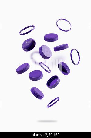 Bouchons de bouteilles en plastique pour le recyclage des vols sur fond blanc. Les capuchons en plastique volent et flottent dans l'air. L'idée de la durabilité environnementale. Banque D'Images