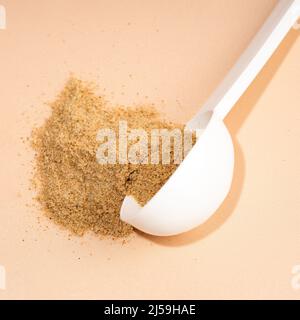 Mélange de supplément de fibres alimentaires . Cuillère blanche de fibres alimentaires sur fond beige. Compléments alimentaires à base de plantes. Additifs biologiquement actifs Banque D'Images