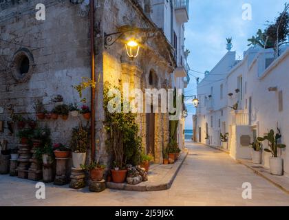 Monopoli - l'allée de la vieille ville avec la petite chapelle au crépuscule. Banque D'Images