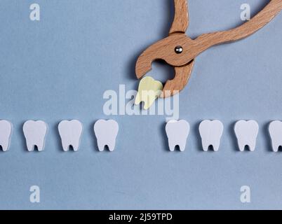 Extraction chirurgicale de la mauvaise dent malade à l'aide de pinces. Carie dentaire, infection. Concept de problèmes dentaires. Concept d'hygiène buccale. Jouet pour enfants. Photo de haute qualité Banque D'Images