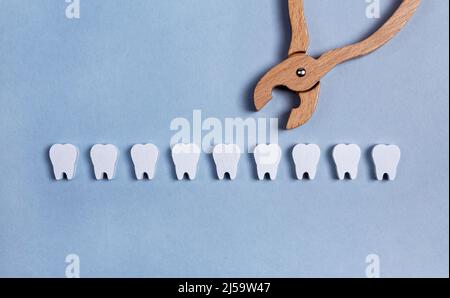 Les dents sont rangées avec des pinces. Extraction dentaire chirurgicale ou implantation dentaire. Opération de dépose. Soins de santé, concept de stomatologie. Jouet pour enfants. Photo de haute qualité Banque D'Images