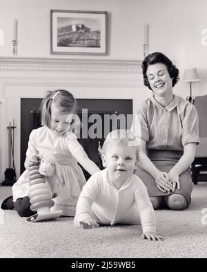 1960S MÈRE ASSISE SUR LE SOL JOUANT AVEC SES DEUX FILLES PLUS JEUNE UN BÉBÉ RAMPANT VERS REGARDER LA CAMÉRA - J11645 HAR001 HARS PLANCHER NOSTALGIQUE PAIRE BEAUTÉ SUBURBAIN URBAIN SES MÈRES VIEUX TEMPS OCCUPÉ FUTUR NOSTALGIE VIEILLE MODE SOEUR 1 JUVÉNILE RIRE ÉQUILIBRE SÉCURITÉ TRAVAIL D'ÉQUIPE BÉBÉ TAPIS HEUREUX JOIE STYLE DE VIE SATISFACTION FEMMES MAISONS VIE COPIE ESPACE PLEINE LONGUEUR DEMI-LONGUEUR FEMMES FILLES PERSONNES BÂTIMENTS RÉSIDENTIELS FRÈRES ET SŒURS VERS LA CONFIANCE SŒURS RAMPANT B&W CONTACT VISUEL BONHEUR TÊTE ET ÉPAULES GAIE LOISIRS PROTECTION EXCITATION BASSE AFFICHEZ VOTRE FIERTÉ DES LOISIRS Banque D'Images