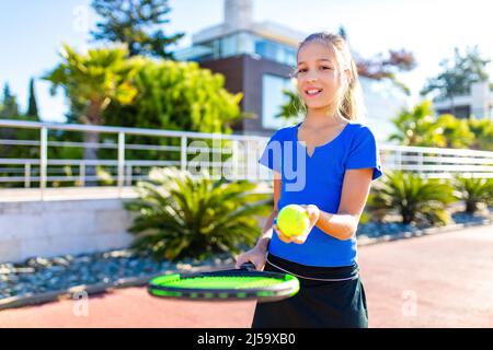 petite girk jouant au tennis dans un endroit tropical à l'extérieur Banque D'Images