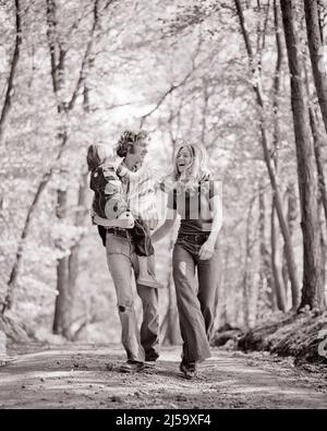 1970S FAMILLE MÈRE PÈRE PORTANT SON FILS MARCHE FORÊT RUELLE RIANT SOURIRE EN PORTANT BELL JEANS DE FOND - J13490 HAR001 HARS 3 DAD EXERCICE MOM VÊTEMENTS PAYS NOSTALGIQUE ACTIVE PAIRE BELL JEANS MÈRES TOUCHANT LE VIEUX TEMPS HIPPIE NOSTALGIE EMBRASSANT LA VIEILLE MODE 1 FORME PHYSIQUE STYLE JUVÉNILE RIRE SAIN JEUNE ADULTE EMBRASSER COTON FILS HEUREUX FAMILLES JOIE STYLE DE VIE FEMMES ÉPOUSÉ FOND RURAL CONJOINT MARIS SANTÉ MAISON VIE NATURE COPIE ESPACE AMITIÉ PLEINE LONGUEUR CÂLIN FEMMES PERSONNES S'OCCUPANT HOMMES HIPPIES DENIM EMBRASSANT PÈRES B&W LANE PARTENAIRE LIBERTÉ ACTIVITÉ BONHEUR PHYSIQUE Banque D'Images