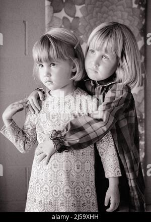 1960S PORTRAIT DE DEUX SŒURS BLONDES GRAVES EXPRESSIONS DU VISAGE DEBOUT ENSEMBLE FILLE PLUS ÂGÉE TENANT EMBRASSER LE PLUS JEUNE - J13596 HAR001 HARS TRAVAIL D'ÉQUIPE EMBRASSER INQUIÉTUDE FORTE RÉSUMÉ FAMILLES STYLE DE VIE FEMMES MOODY MAISON VIE COPIE ESPACE AMITIÉ DEMI-LONGUEUR HUG ATTENTIONNÉ FRÈRES ET SŒURS EMBRASSER LES EXPRESSIONS DE SŒURS TROUBLÉE B&W CONCERNÉ TRISTESSE DÉCOUVERTE PROTECTION DE L'HUMEUR FRÈRE ET SŒUR LIEN CONCEPTUEL GLUM ÉLÉGANT SINCÈRE ATTACHEMENT PERSONNEL AFFECTION SOLENNELLE COOPÉRATION ÉMOTION DE CROISSANCE INTENSE JUVÉNILES MISÉRABLE JEUNE NOIR ET BLANC ATTENTION RACE BLANCHE HAR001 Banque D'Images