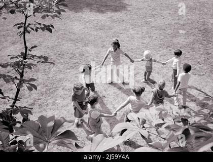 1970S DIVERS GROUPES D'ENFANTS TENANT LES MAINS MARCHANT DANS UN CERCLE JOUANT AUTOUR DE LA ROSIE DANS L'HERBE - J14495 HAR001 HARS COPIER ESPACE AMITIÉ PERSONNES PLEINE LONGUEUR HOMMES CHANTANT B&W GRAND ANGLE ORIENTAL AFRO-AMÉRICAINS AFRICAN-AMERICAN RÉCRÉATION NOIR ETHNICITÉ MAIN DE MAIN ASIATIQUE AMÉRICAINE LA PÉPINIÈRE DE PESTE DE ROSIE RHYME ROSÉ COOPÉRATION ASIATIQUE-AMÉRICAINE ANNEAU DE CROISSANCE AUTOUR DE LA TOGETHNESS DE ROSIE NOIR ET BLANC ORIGINE ETHNIQUE CAUCASIENNE HAR001 AFRO-AMÉRICAINS À L'ANCIENNE Banque D'Images