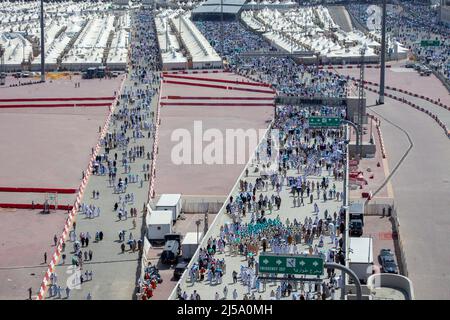 Pèlerins marchant à travers des sentiers vers leurs destinations rituelles pendant la saison du hadj à Mina Arabie Saoudite Banque D'Images