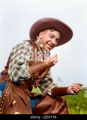 1920S SOURIANT HOMME DANS LE COW-BOY BONNET GILET BRASSARDS ET CHAPS ROULER CIGARETTE REGARDANT L'APPAREIL-PHOTO - T488C HAR001 FUMEURS HARS GAI TABAC GAI BRASSARDS HONNÊTES ENTERTABACS PROFESSIONNELS SOURIANTS FUMEUR JOYEUSE CHAPS ADULTE MOYEN-ADULTE HOMME CAUCASIEN ETHNICITÉ HAR001 OLD FASHIONED Banque D'Images