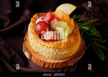 délicieuse tarte feuilletée aux baies rouges faites à la maison, placée sur un bois et sur un café le tissu de satin, cuisine gastronomique saine alimentation Banque D'Images