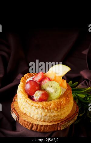 délicieuse tarte feuilletée aux baies rouges faites à la maison, placée sur un bois et sur un café le tissu de satin, cuisine gastronomique saine alimentation Banque D'Images