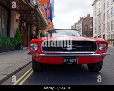 Londres, Grand Londres, Angleterre, avril 09 2022 : voiture mustang rouge à l'extérieur de l'hôtel Claridge. Banque D'Images