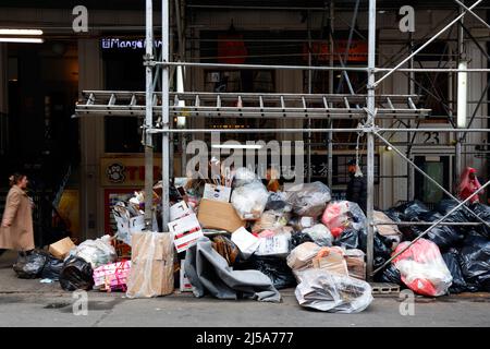 Les déchets commerciaux et ménagers du trottoir s'entassés sous un abri de trottoir, un échafaudage de trottoir sur un trottoir de la ville de New York dans l'East Village Banque D'Images