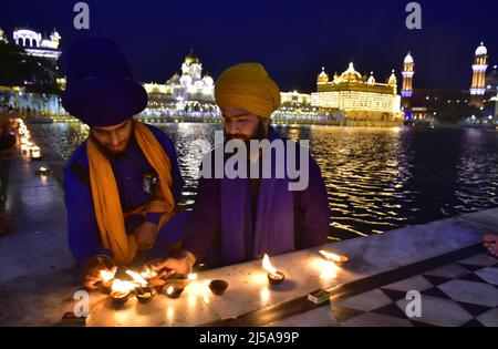 Amritsar, Inde. 21st avril 2022. AMRITSAR, INDE - AVRIL 21 : bougies légères des dévotés au Temple d'Or à l'occasion du 400th anniversaire de naissance de Guru Teg Bahadur le 21 avril 2022 à Amritsar, Inde. (Photo par Sameer Sehgal/Hindustan Times/Sipa USA) crédit: SIPA USA/Alay Live News Banque D'Images